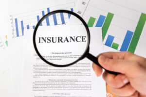 Man looking through magnifying glass blank insurance claim form | Fatal Accident Claims